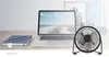 A desk setup with a laptop, notebook, pens, and a small desk fan. Produktbild-Vorschau