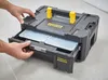 A person's hands are shown opening a drawer on a black STANLEY FATMAX TSTAK tool box. Voir les images du produit