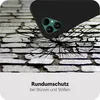 A black phone case is shown falling onto a cracked stone surface, illustrating its protective qualities. Produktbild-Vorschau