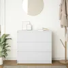 A white three-drawer dresser is shown in a room with a mirror and a plant. Produktbild-Vorschau