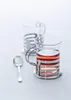 Two glass tea cups with metal holders and a spoon on a light gray surface. Produktbild-Vorschau