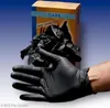 A hand wearing a black nitrile glove holds a crumpled pile of black nitrile gloves, with a box of black nitrile gloves in the background. Náhľad obrázku produktu