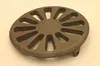 A round, cast iron grate with a spoke-like pattern and a small leg on the side, placed on a light gray background. Podgląd zdjęcia produktu