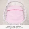 A pink bedding set inside a white wicker bassinet. Produktbild-Vorschau