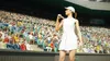A female tennis player in a white dress and cap stands on a court with a packed stadium in the background. Produktbild-Vorschau