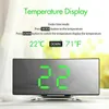 A digital alarm clock with a mirrored display showing the temperature and time, with instructional text above. Produktbild-Vorschau