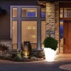A modern house entrance at dusk, featuring illuminated planters and a large decorative pot. Produktbild-Vorschau