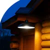 A solar-powered hanging lamp illuminates the entrance of a log cabin at dusk. Anteprima dell’immagine prodotto
