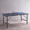 A blue ping pong table with two paddles and three balls on it, set against a tiled wall. Produktbild-Vorschau