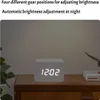 A digital clock with a wooden casing is placed on a wooden table. Produktbild-Vorschau