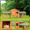 A multi-panel image showing a wooden rabbit hutch with green roofing, set in a grassy outdoor environment with trees in the background. One panel shows a close-up of a rabbit inside a compartment of the hutch. Produktbild-Vorschau