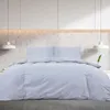 A bed with gray bedding in a modern room. Náhľad obrázku produktu