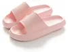 Paar hellrosa Chunky-Slide-Sandalen mit strukturierten Riemen und Sohlen, aus leichtem Winkel betrachtet