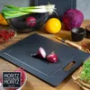 A collection of fresh produce and a cutting board on a wooden table. Anteprima dell’immagine prodotto