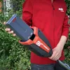 A person holding a battery pack for a garden tool. Anteprima dell’immagine prodotto