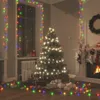 A decorated Christmas tree with presents underneath, and Christmas lights strung around the room. Produktbild-Vorschau