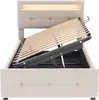 A beige upholstered bed frame with its mattress support slats lifted, revealing storage space underneath. The headboard has integrated LED lighting. Produktbild-Vorschau