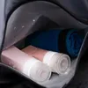 Inside of a bag with toiletries and a rolled-up towel. Voir les images du produit