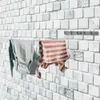 Clothes drying on a retractable clothesline mounted on a tiled wall. Podgląd zdjęcia produktu