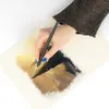 A person's hand is painting on a canvas with a brush. Produktbild-Vorschau