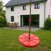 A red disc swing hangs from a rope in front of a modern house with a patio and garden. Anteprima dell’immagine prodotto