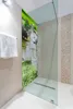 A modern bathroom with a glass shower enclosure featuring a scenic waterfall mural. Produktbild-Vorschau