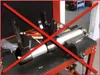 A tool is clamped in a vise on a workbench, with red X marks overlaid on the image. Voir les images du produit