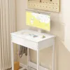 A white desk with a monitor, keyboard, and a purse and jacket hanging from it. Náhľad obrázku produktu