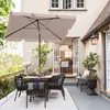 An outdoor patio setting with a dining table and chairs under a large umbrella. Produktbild-Vorschau