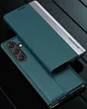 A teal smartphone case with a silver accent strip is shown in a studio setting with a dark, reflective background. Produktbild-Vorschau