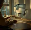 A person is working at a desk with a computer monitor on a stand. Produktbild-Vorschau