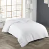A white duvet and duvet cover are laid out on a bed with a herringbone patterned wooden floor. Produktbild-Vorschau