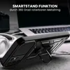A black phone case with a kickstand is shown on a table next to headphones and a laptop. Produktbild-Vorschau