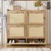 A wooden shoe cabinet with rattan doors and open storage is shown in a hallway setting. Náhľad obrázku produktu