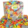A box of Meli Basic Constructor building blocks is shown, surrounded by scattered blocks and some assembled structures. Produktbild-Vorschau