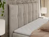 A close-up view of a beige upholstered bed frame with a mattress and topper. Produktbild-Vorschau