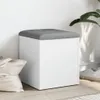 A white storage bench with a gray upholstered top sits on a light wooden floor next to a white wall. A light-colored tote bag is to the left, and a plant is to the right. Podgląd zdjęcia produktu