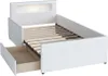 A white bed frame with a slatted base and an open drawer, shown from a diagonal angle against a white background. Produktbild-Vorschau
