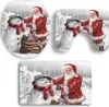 Three Christmas-themed bath mats featuring Santa Claus and snowmen in a snowy village setting. Produktbild-Vorschau