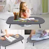 A collage of three images showing a young girl drawing at a portable table, a person reading a book with a coffee cup on the table, and a person ironing clothes on the table. Produktbild-Vorschau