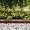 A garden bed with a tree and bushes, bordered by gravel and a metal edge. Náhled obrázku produktu