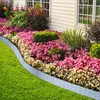 A garden bed with colorful flowers and green grass, bordered by a grey rattan-look edging. Produktbild-Vorschau