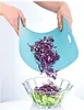 Hands holding a flexible blue cutting board, pouring chopped red cabbage into a glass bowl with lettuce. Náhled obrázku produktu