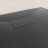 A close-up view of a black shower tray with a drain cover. Produktbild-Vorschau