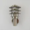 A silver outdoor wall light with a tiered design is mounted on a white wall. Produktbild-Vorschau