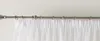 A close-up view of white sheer curtains hanging from a metal curtain rod. Produktbild-Vorschau