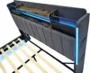 A close-up view of a modern bed frame's headboard with integrated storage and LED lighting. Produktbild-Vorschau