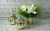 Decorative ceramic fruits and a vase of white tulips on a brick background. Anteprima dell’immagine prodotto