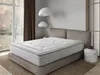 A bedroom scene with a mattress on a bed frame, next to a window and a side table. Produktbild-Vorschau