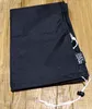 A black umbrella cover is folded and placed on a wooden surface. Produktbild-Vorschau